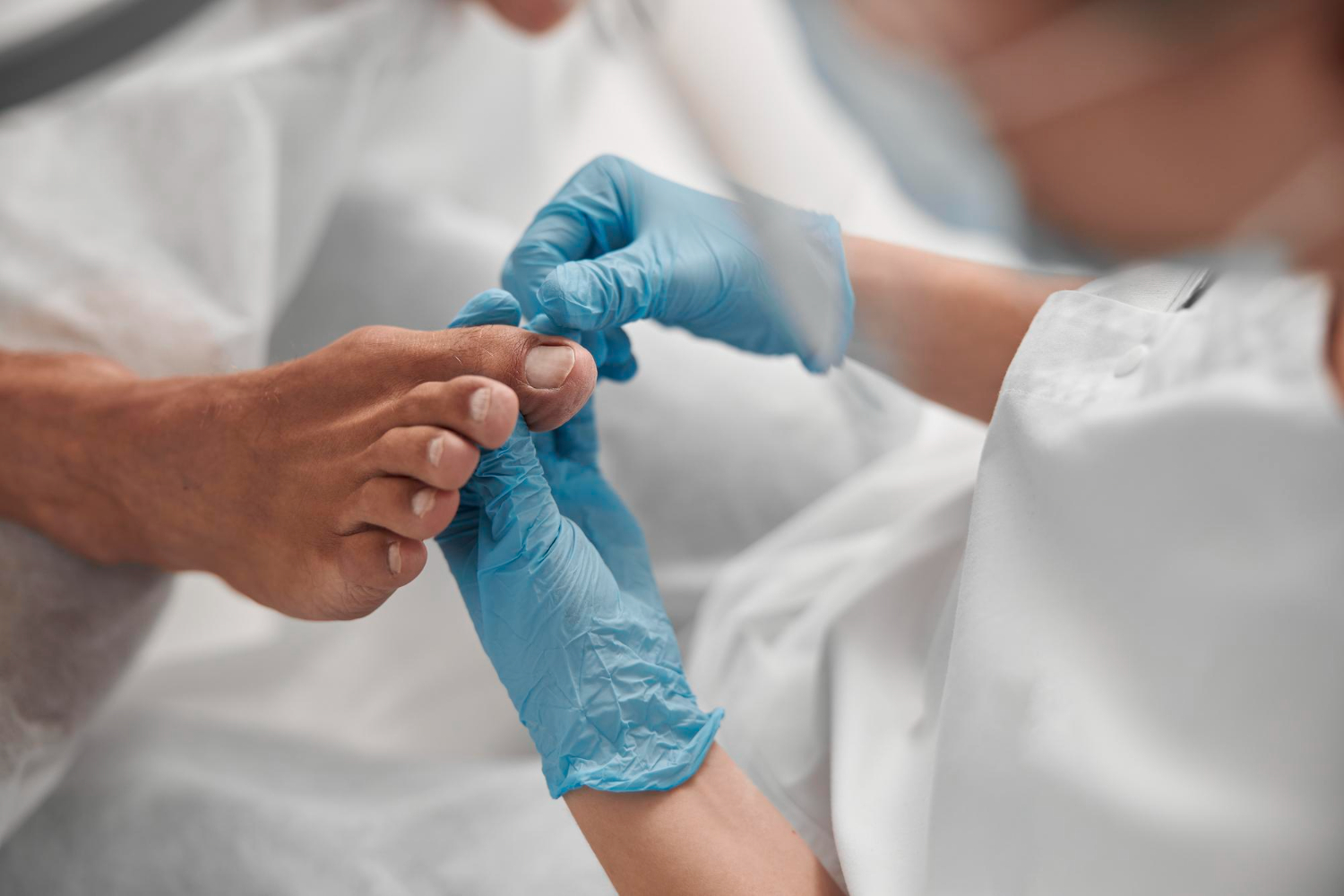 podolog ogląda stopy pacjenta